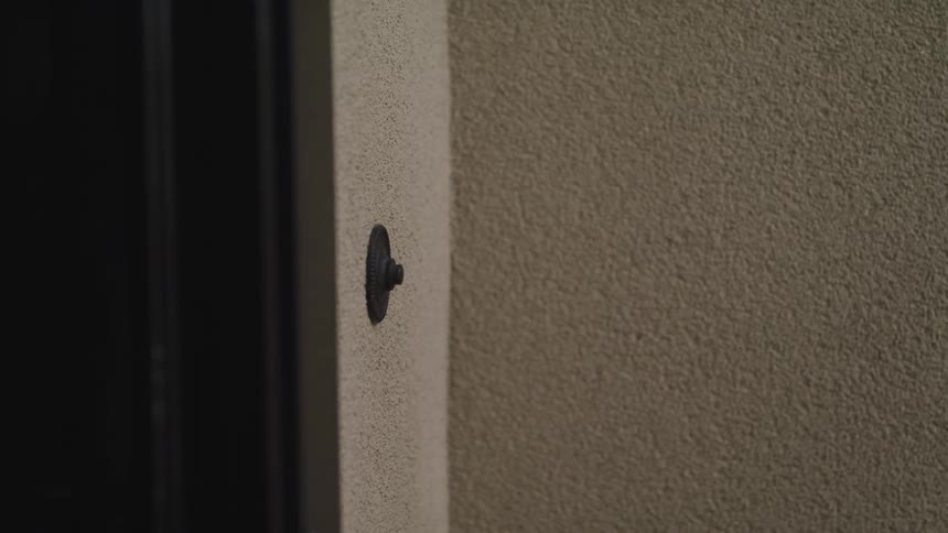 Hand reaching out to ring the door bell