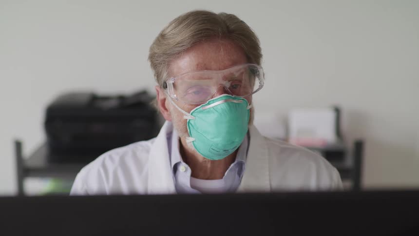 A doctor sitting and looking at a computer