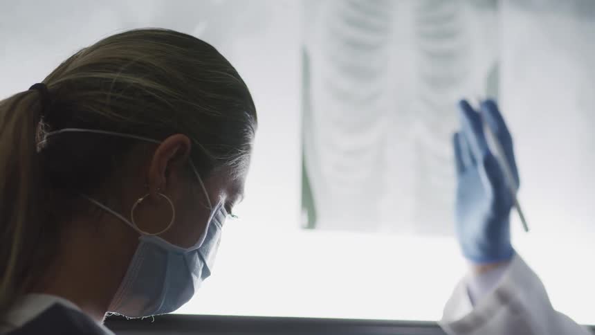 Two doctors are looking at an x ray in a lab