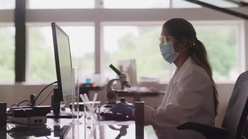 Scientist working in a laboratory types on the keyboard