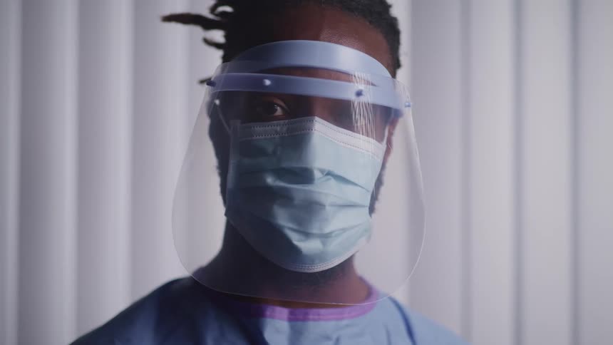 A doctor is in a hospital while wearing a face mask