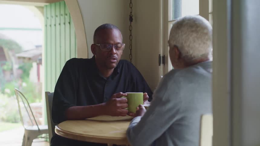 Two people are sitting down drinking coffee