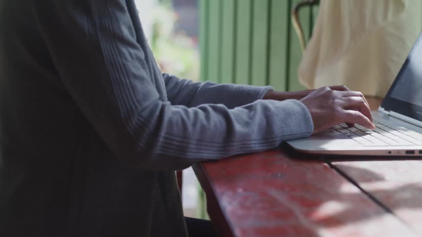 A man is typing on a laptop