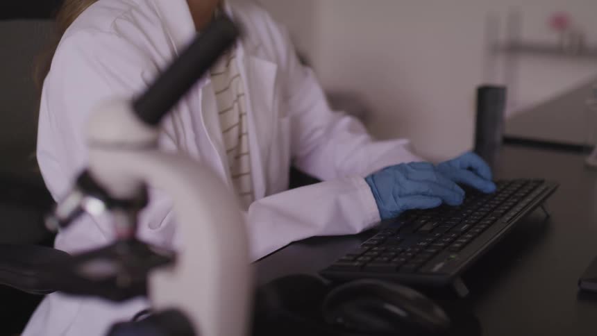 A scientist is typing on the keyboard