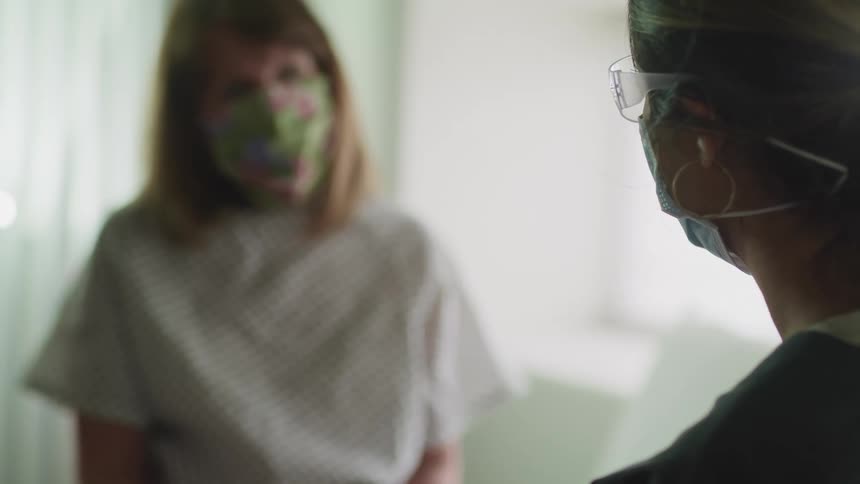 A nurse speaks with a patient in a doctors office