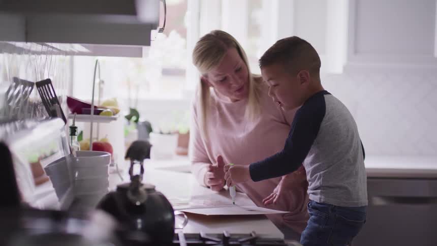 Young boy and his mother have fun in the kitchen