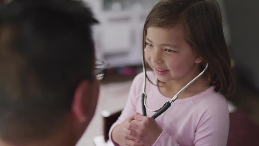 A little girl holds a doctors stethoscope
