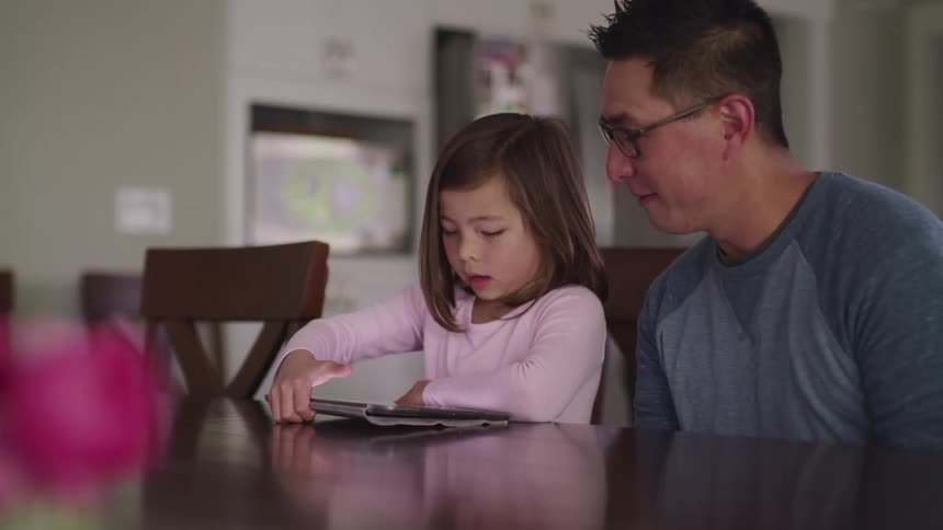 A man and child use a tablet together