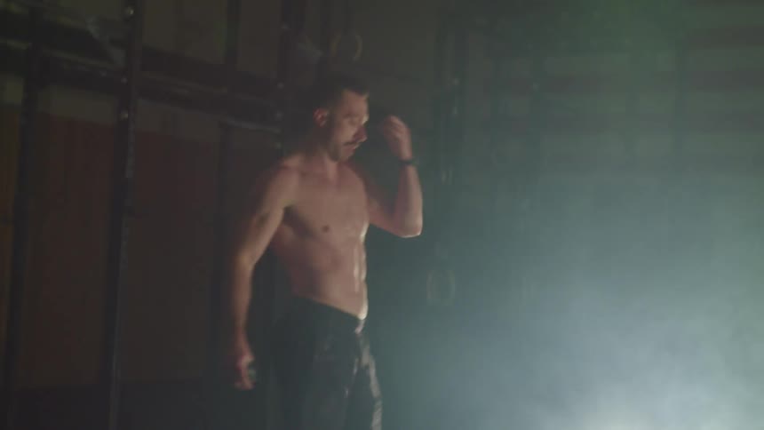Muscular man warms up to work out in a gym