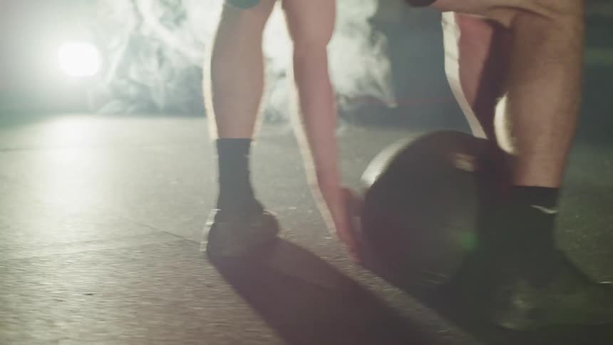 A man is tossing a medicine ball around the gym