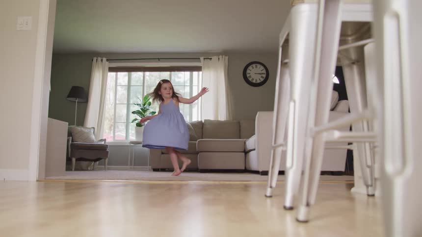 A child is dancing in the living room