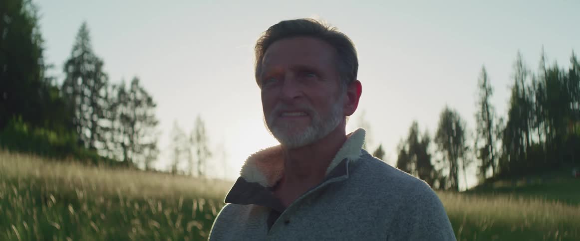 The sun is rising behind the man