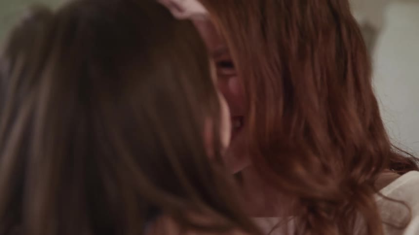 A mother and daughter laugh then butt noses