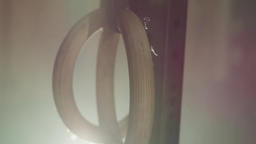 Wooden rings hang on bar in foggy room