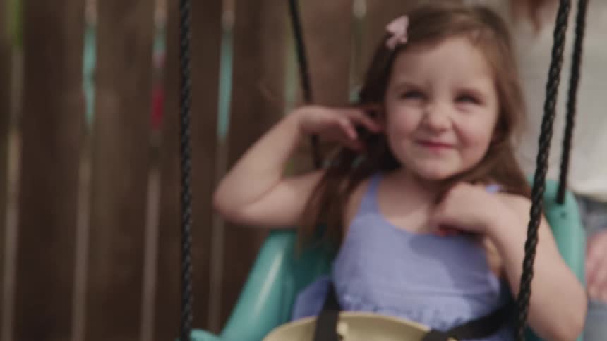 A child is being pushed on the swing
