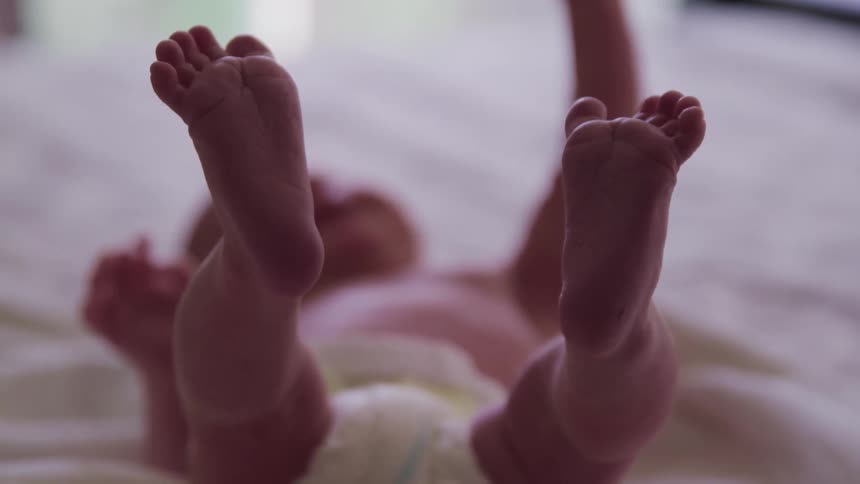 Baby lays on his back with his feet in the air