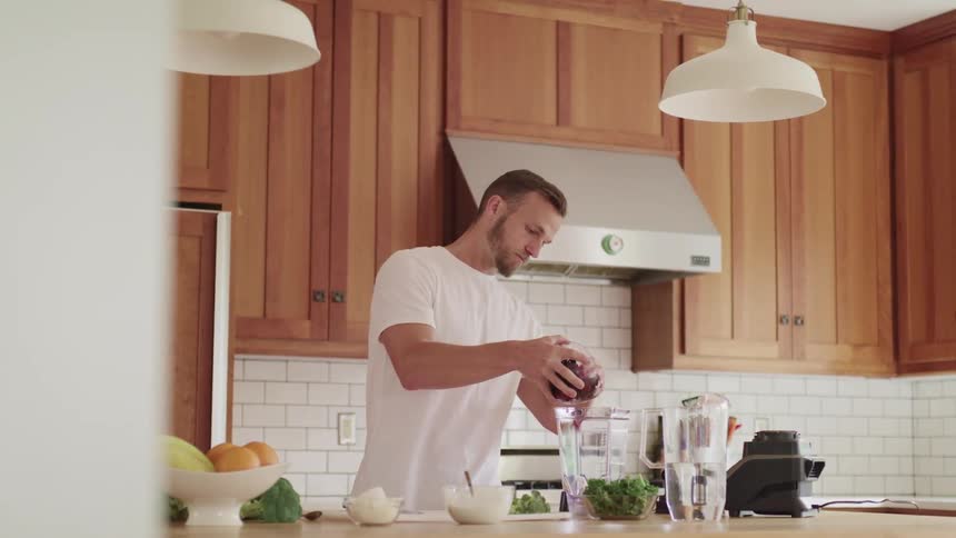 Bearded man in a white sheet cooking in the kitchen at home