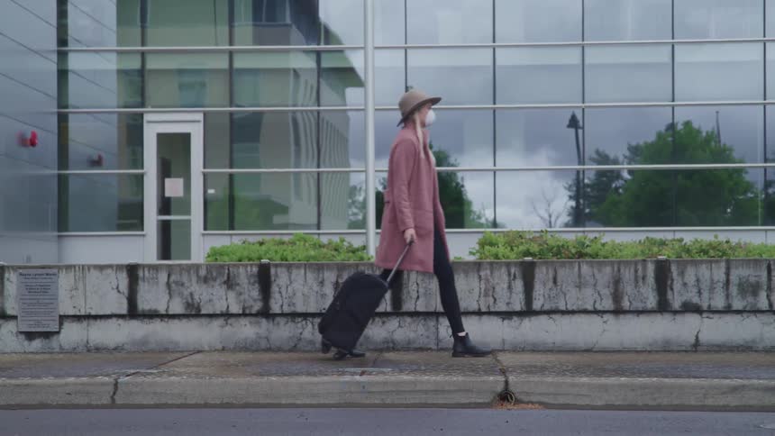 A woman is walking through a downtown city