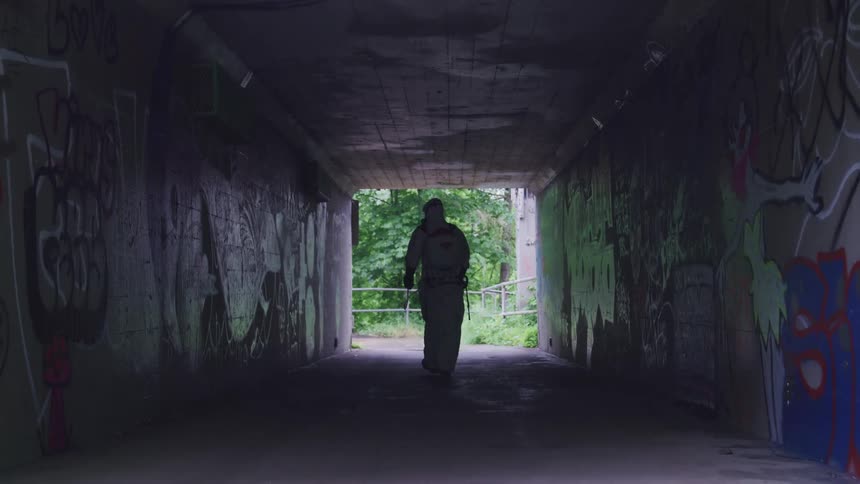A person is cleaning the tunnel graffiti