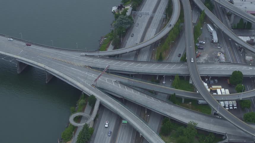 Traffic moving along an overpass with many winding branches on the coast of a city