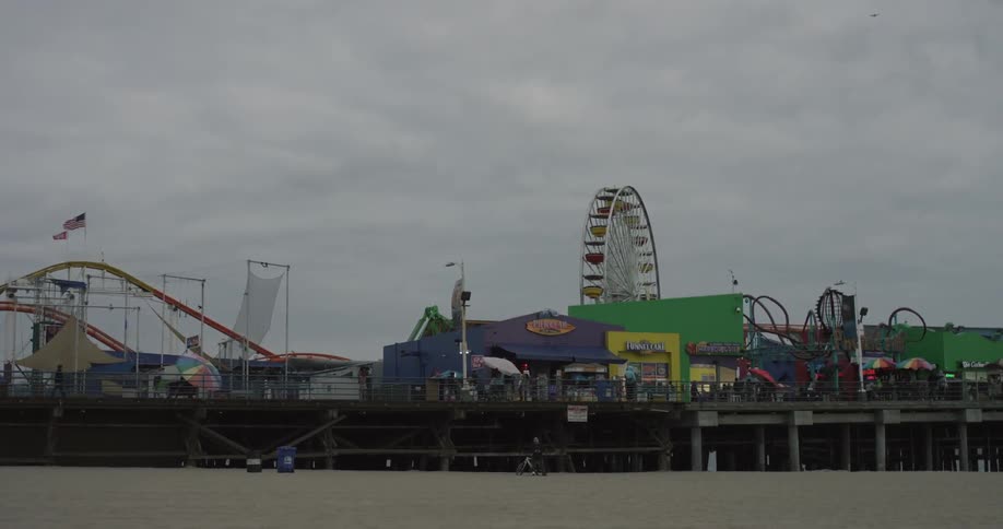A ferris wheel rotates on a pier