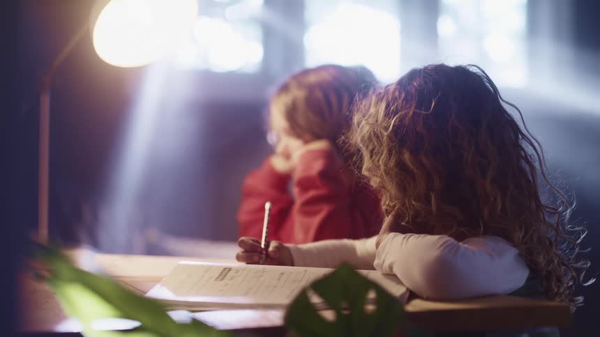 Two kids doing school work at home