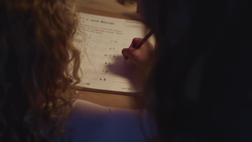 Girl doing homework with her mother at home