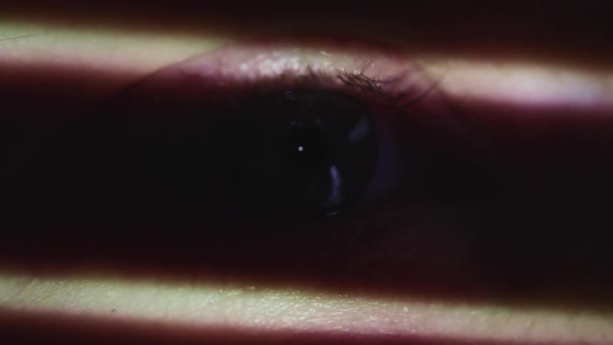Close up of an eye with a light moving down the face