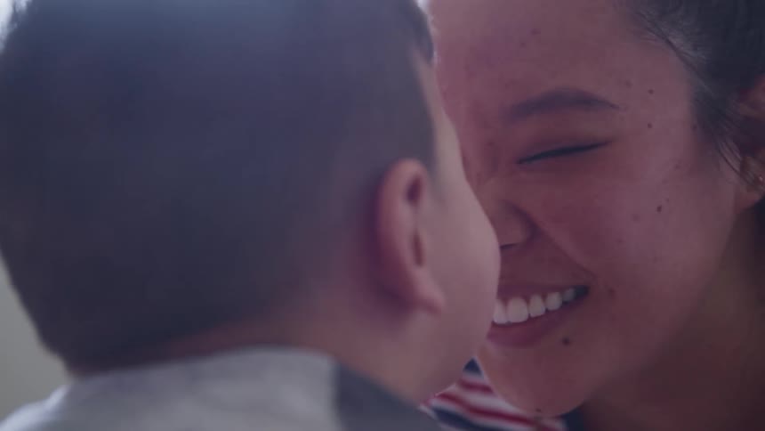 Mother looks at her son affectionately and presses the tip of her nose against her sons nose