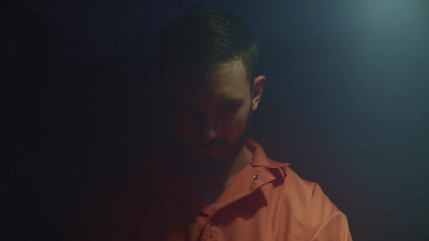 A man looks up as a light flashes around him