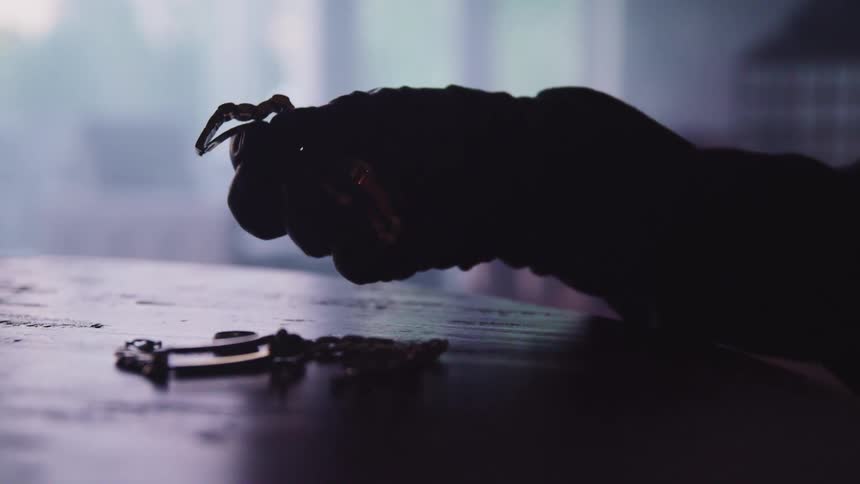 A man picks a watch up off a table