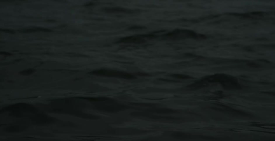 Close up of some wavy water in a dark area