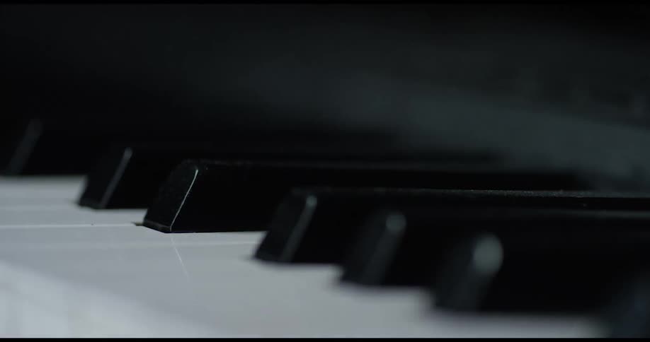 Shadows are creeping over the keys on a piano