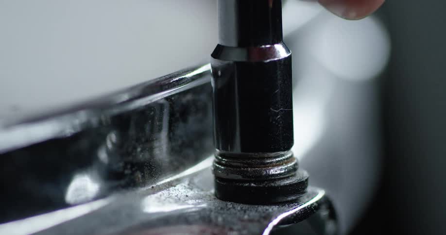 A person places a socket wrench on top of a fastener
