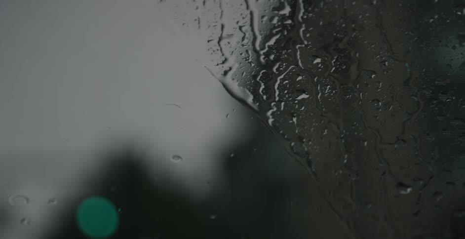 Raindrops fall on windshield than removed by wipers