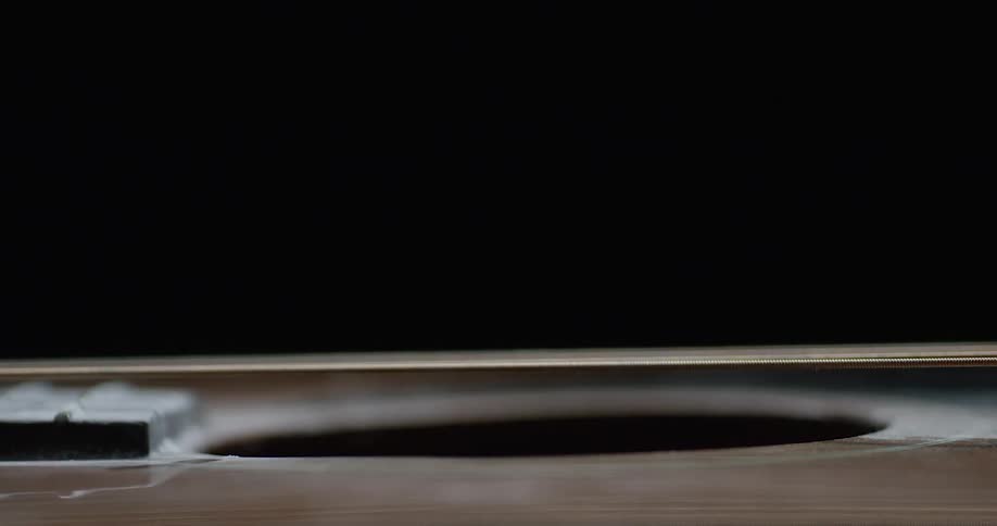 Strings on a musical instrument are being held and released