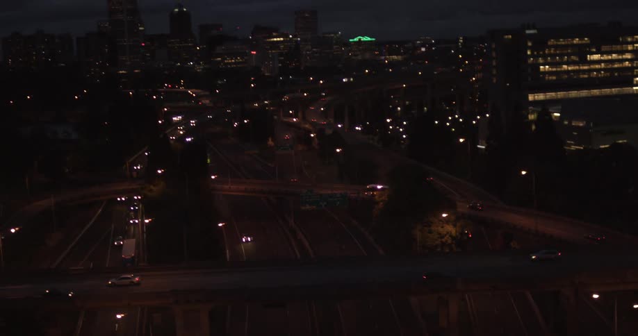 View of traffic travelling on an urban highway system as night falls