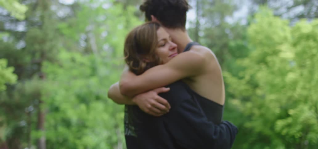 Two people hug by the forest