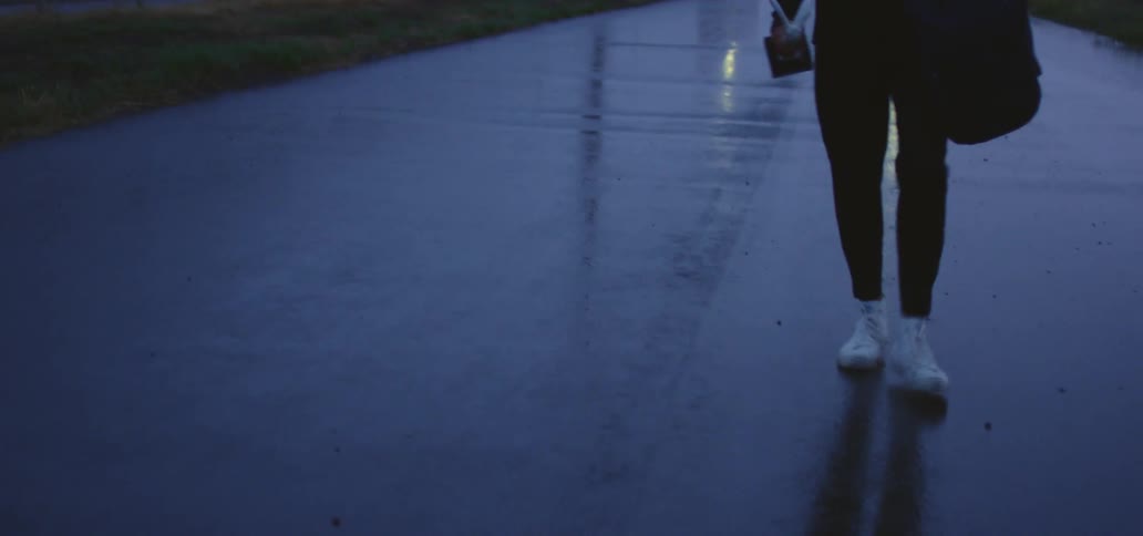 A teenager walking down a street with a slight limp