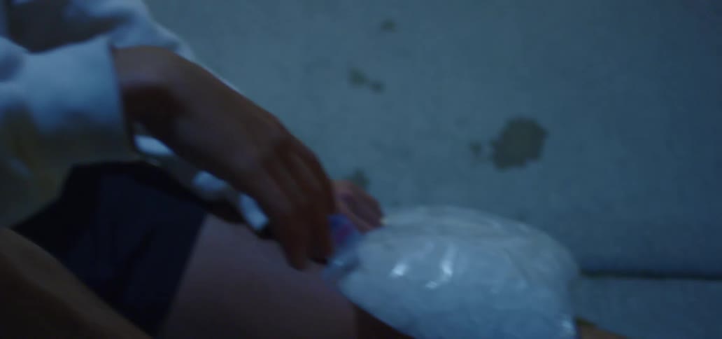 Young man sitting on the ground icing his knee