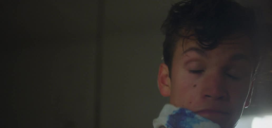 Man dries his face with a towel after the shower