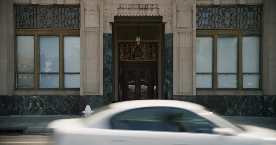 Vehicles drive past the building