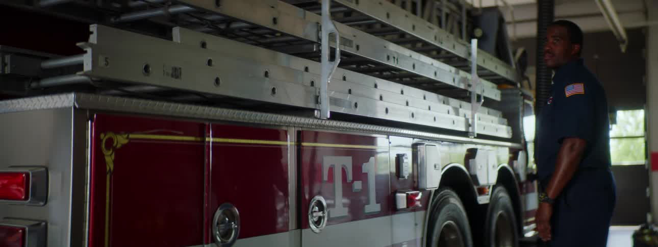 A fire fighter stands in front of a fire engine