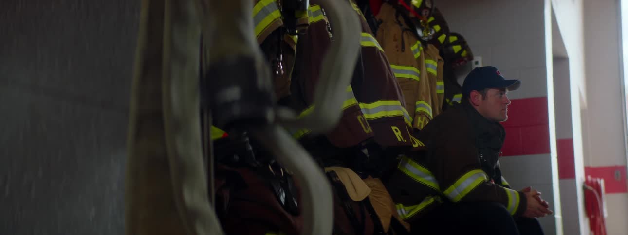 A firefighter is sitting at a fire station