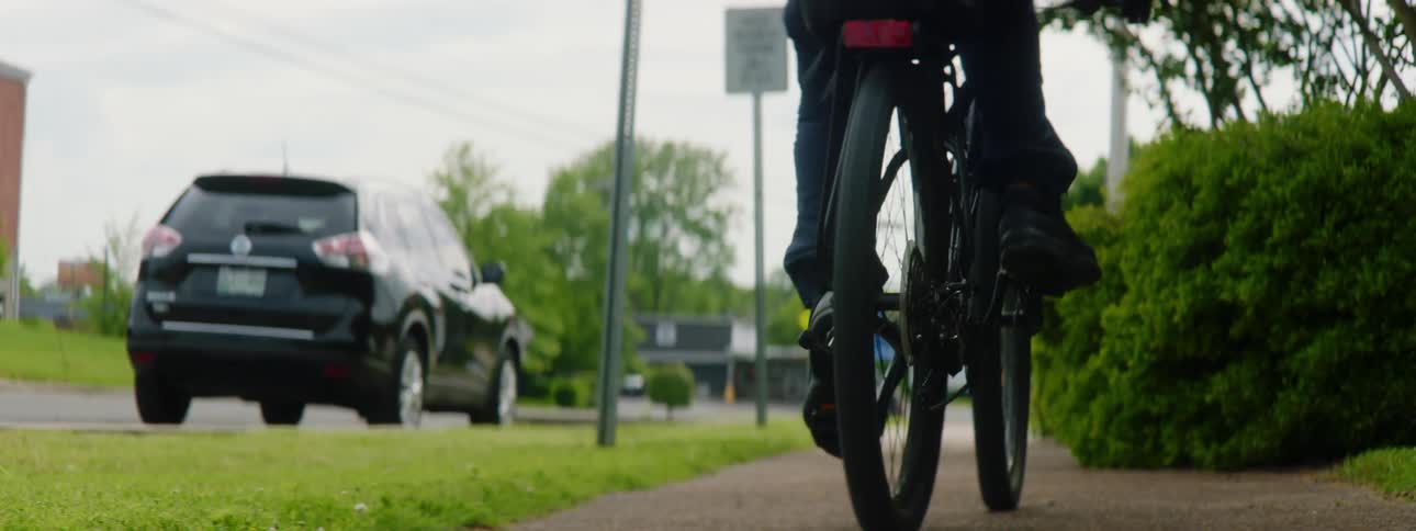 Police officer driving a bicycle patrols the streets of a small town