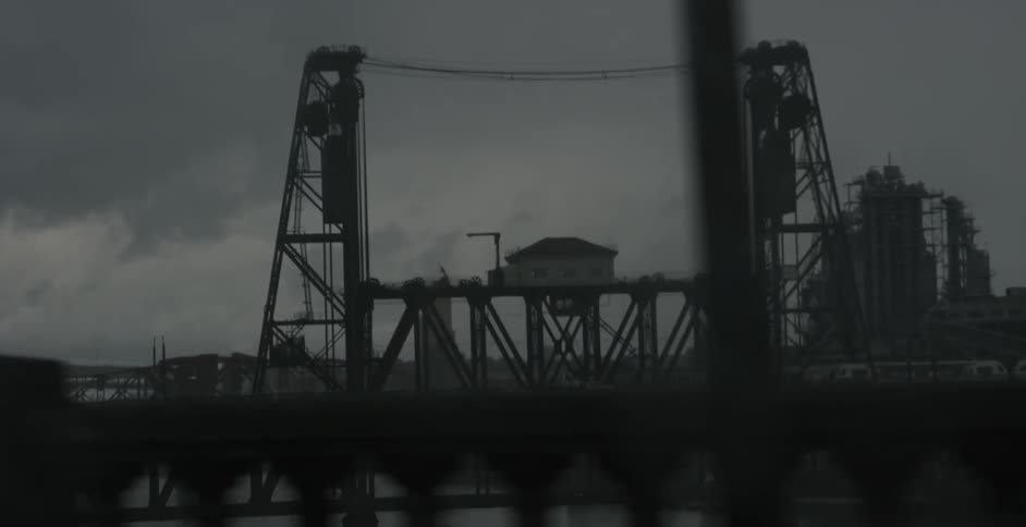 A car drives by a structure on a cloudy day