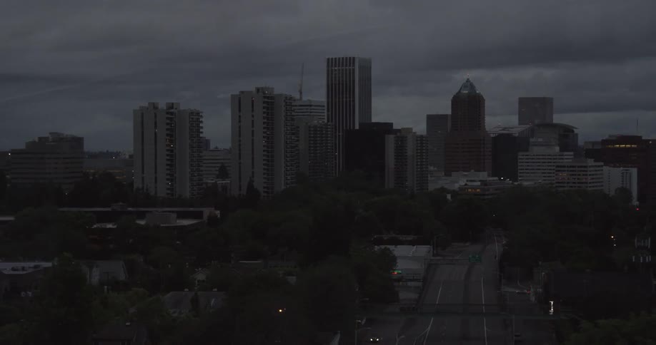 Clouds float over city buildings at night