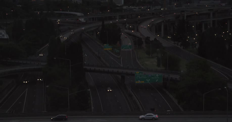 Aerial view of vehicles traveling on a roadway by a city