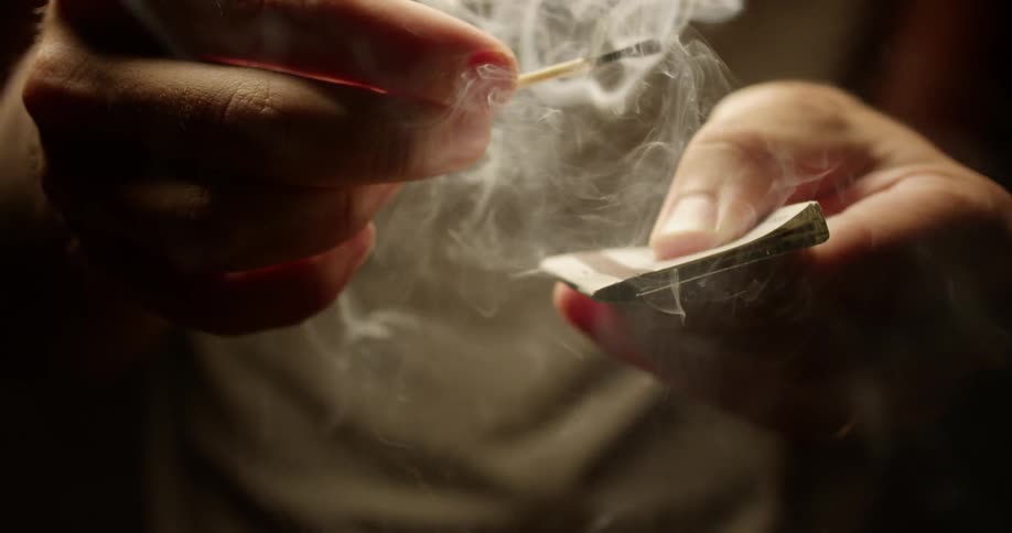 Smoke billows from a burned match