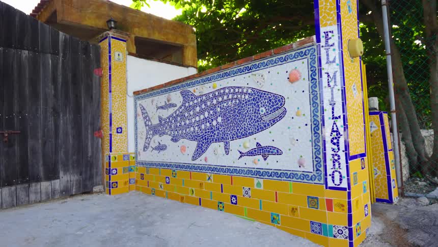 A mosaic of a whale and other sea life on the tiled wall outer wall of a building